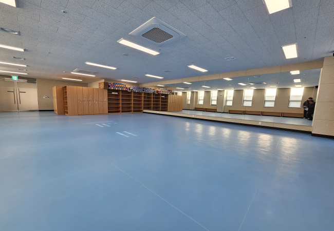 여러명이 거울을 앞에 두고 흥겹게 춤을 추고 있다